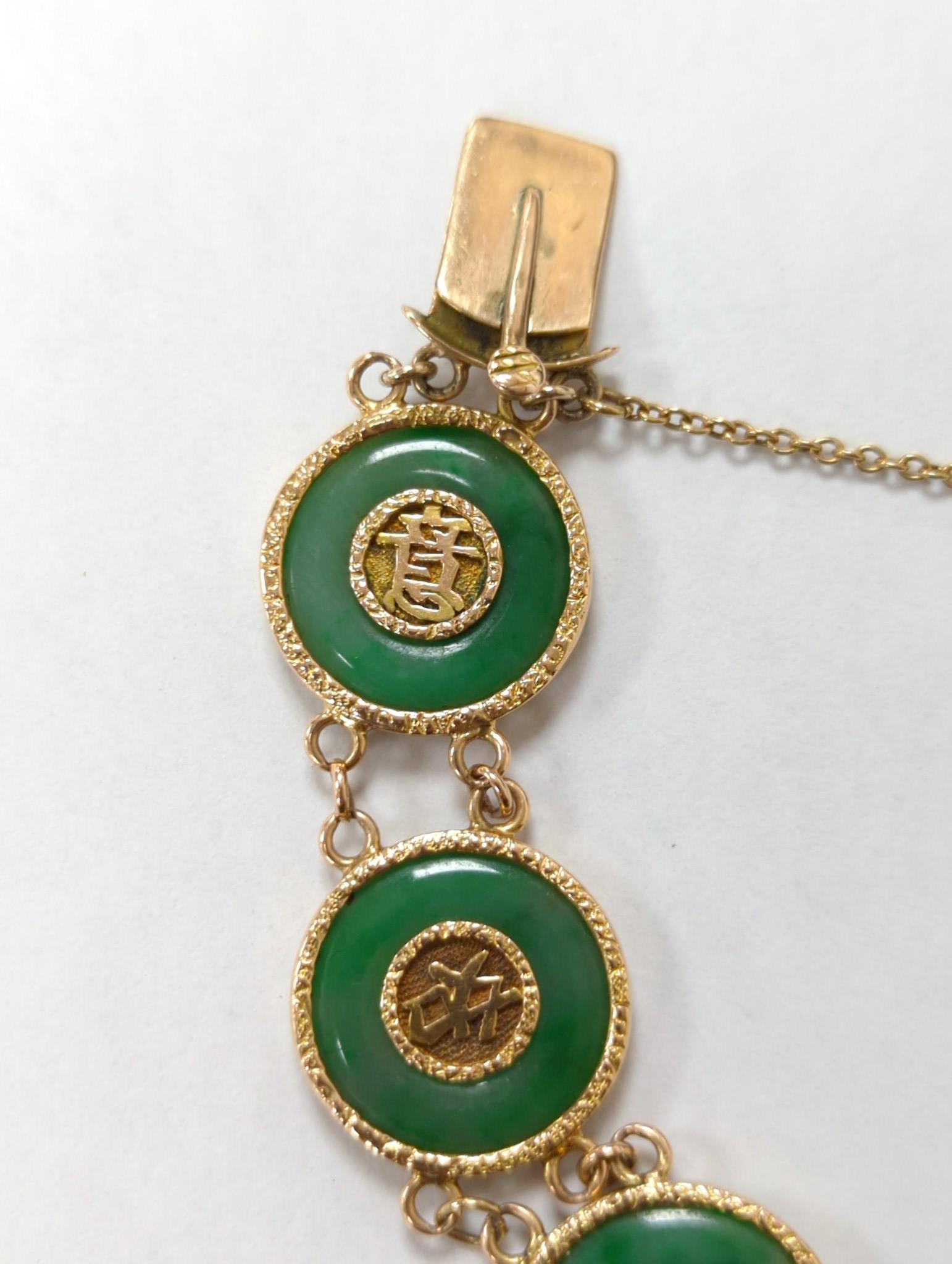 A Chinese yellow metal (stamped 18) and pierced eight stone jade disc set bracelet, with central Chinese characters, 16.5cm approx. gross weight 27.7 grams.